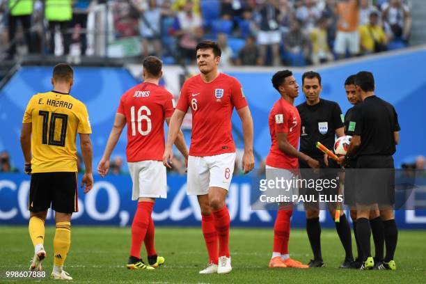England's midfielder Jesse Lingard talks to match officials as England's defender Phil Jones and England's defender Harry Maguire walk past Belgium's...