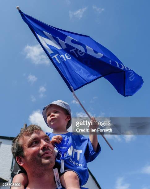 Young boy sits on his father's shoulders and waves a teacher's union flag during the 134th Durham Miners' Gala on July 14, 2018 in Durham, England....