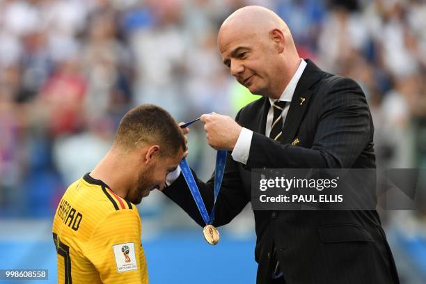 President Gianni Infantino presents the bronze medal to Belgium's forward Eden Hazard following their win in the Russia 2018 World Cup play-off for...