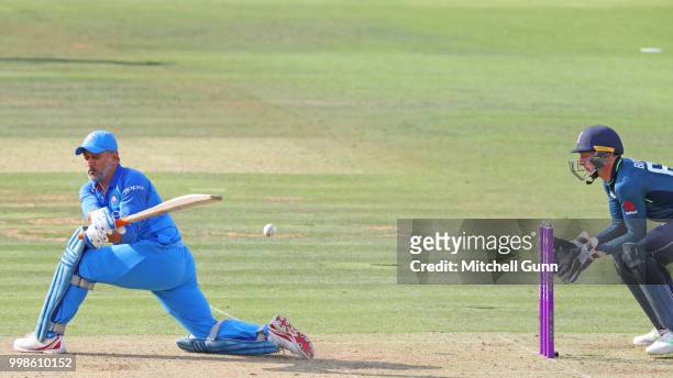 Dhoni of India plays a shot as wicketkeeper Jos Buttler of England looks on during the 2nd Royal London One day International match between England...