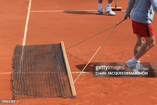 Maintenance workers clean the court between sets during the French Tennis Open at Roland Garros, 31 May 2007 in Paris. AFP PHOTO / JACQUES DEMARTHON