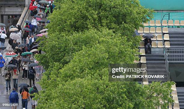 Visitor waits as it rains during the first round of the French Tennis Open, at Roland Garros, in Paris, on May 26, 2008. AFP PHOTO/ PATRICK KOVARIK