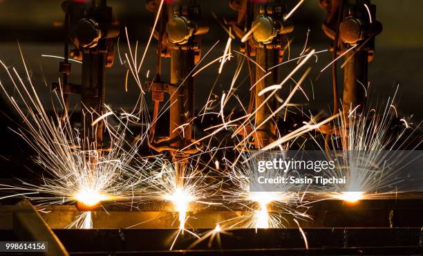 close up of sparks coming off steel as a bar goes through a laser cutting process. - space travel stock-fotos und bilder