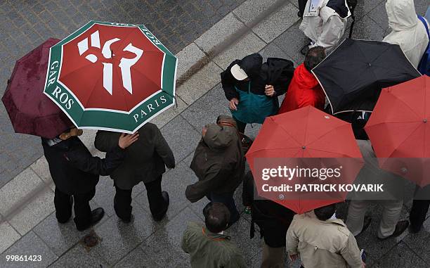 Visitors wait as it rains during the first round of the French Tennis Open, at Roland Garros, in Paris, on May 26, 2008. AFP PHOTO/ PATRICK KOVARIK