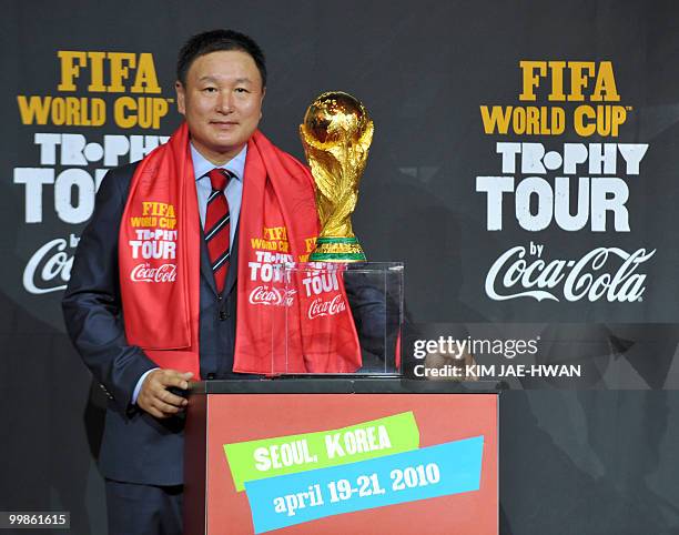 South Korean national football team head coach Huh Jung-Moo poses with the FIFA World Cup trophy during the trophy tour in Seoul on April 20, 2010....