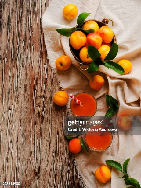 fresh apricot juice in glass on wooden table, selective focus - イエロートマト ストックフォトと画像