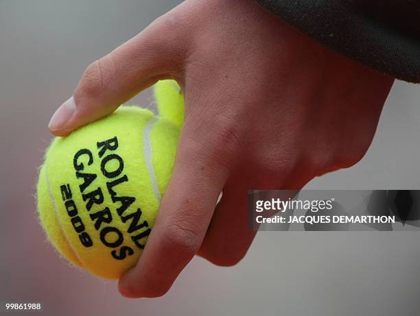 An attendant holds tennis ball during play between Spanish player Nicolas Almagro and Latvia's player Ernests Gulbis during their French Open tennis...