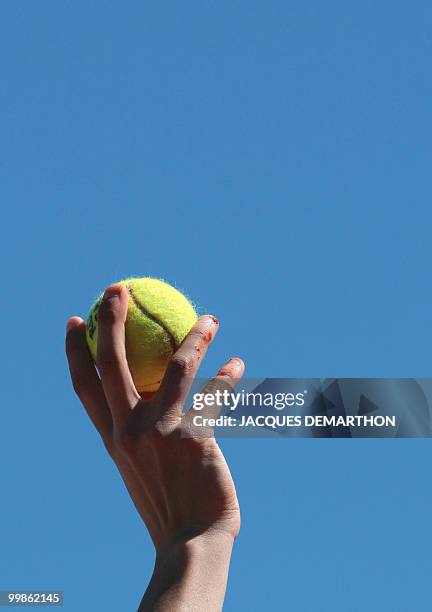 Ball boy raises a ball during play between German player Tommy Haas and French player Jeremy Chardy during their French Open tennis third round match...