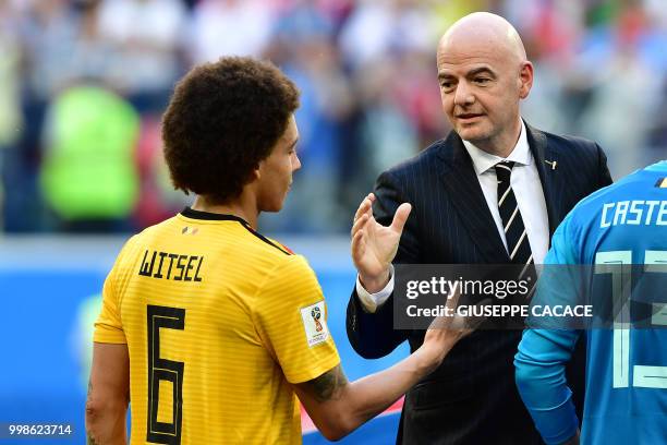 Belgium's midfielder Axel Witsel is congratulated by Swiss-Italian FIFA president Gianni Infantino after their Russia 2018 World Cup play-off for...