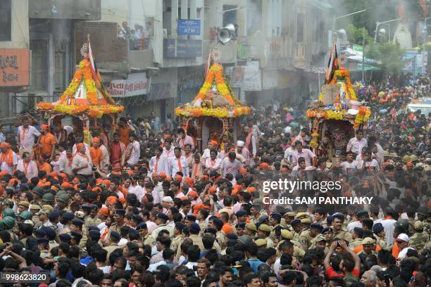 Indian Hindu devotees and security personnel are pictured around chariots with the icon of Lord Jagannath, sister Subhadra and brother Balaram in...