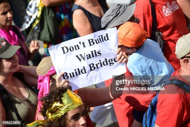 Woman holds a banner reading "Don't build walls, build bridges" during a demonstration at the call of an Italian association to help migrants...