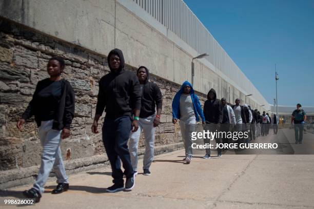 Migrants are transfered after arriving aboard a coast guard boat at Tarifa's harbour on July 14, 2018. - Spanish rescuers saved more than 340...