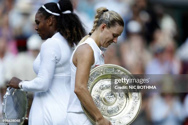 Germany's Angelique Kerber carries the winner's trophy, the Venus Rosewater Dish, after her women's singles final victory over US player Serena...