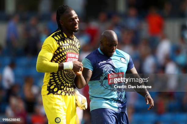 Adebayo Akinfenwa of Wycombe Wanderers embraces team-mate Yves Ma-Kalambay after the pre-season friendly match between Wycombe Wanderers and West Ham...