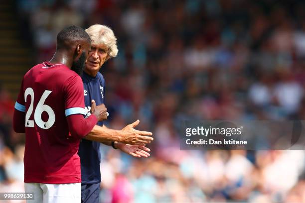 West Ham manager Manuel Pellegrini speaks with Arthur Masuaku during the pre-season friendly match between Wycombe Wanderers and West Ham United at...