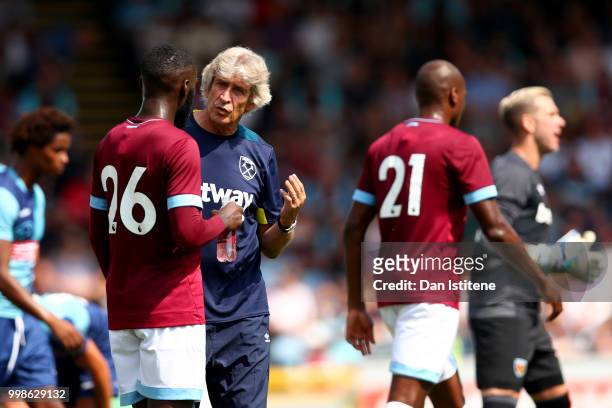 West Ham manager Manuel Pellegrini speaks with Arthur Masuaku during the pre-season friendly match between Wycombe Wanderers and West Ham United at...