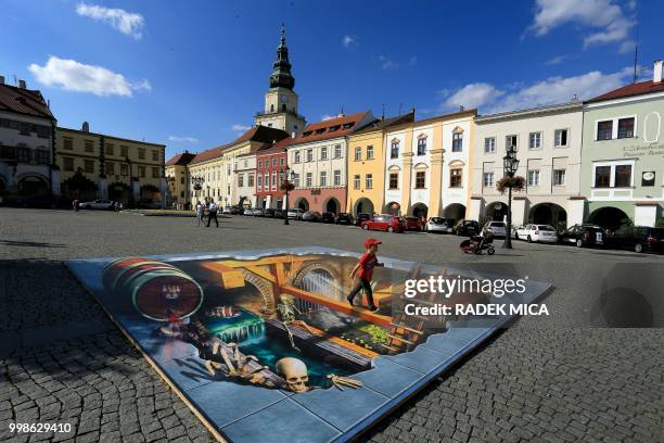 Picture taken on July 13, 2018 shows a 3D street painting on the main square in the Czech city of Kromeriz with the castle in the background. -...