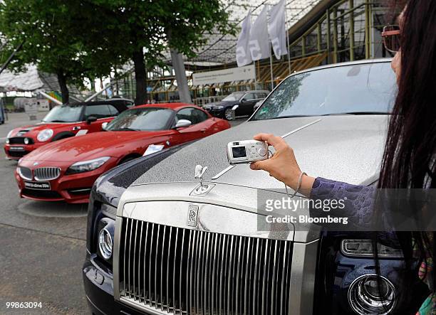 Visitor takes a photo of a Rolls-Royce automobile at the Bayerische Motorenwerke shareholders' meeting, in Munich, Germany, on Tuesday, May 18, 2010....
