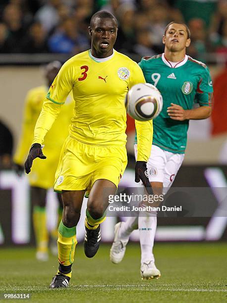 Alpha Ba of Senegal chases down the ball in front of Javier Hernandez of Mexico during an international friendly at Soldier Field on May 10, 2010 in...