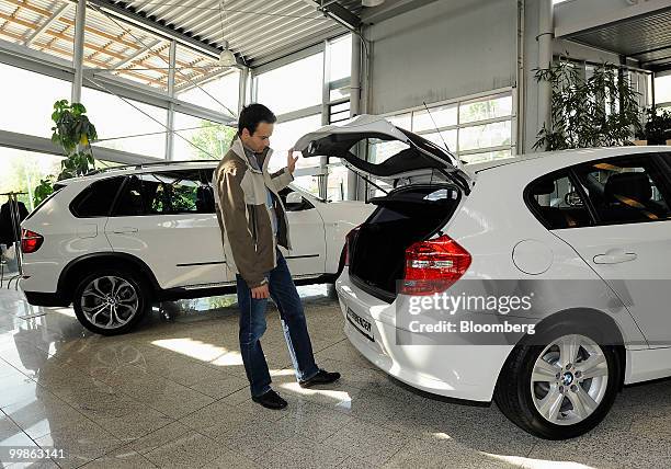 Customer looks inside a Bayerische Motoren Werke 1 series automobile at a BMW car dealership in Rosenheim, Germany, on Tuesday, May 18, 2010....