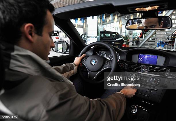 Customer sits in a Bayerische Motoren Werke 3 series cabriolet automobile at a dealership in Rosenheim, Germany, on Tuesday, May 18, 2010. Bayerische...