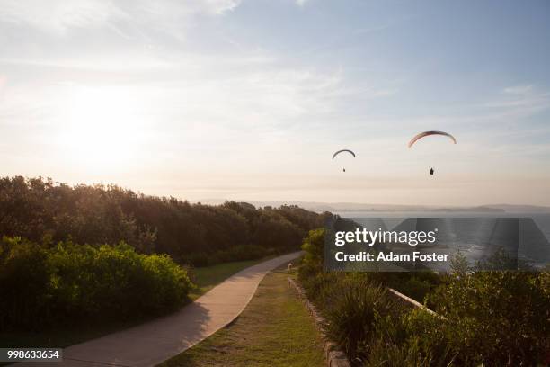 sunset paragliders at long reef point - sunset point stock pictures, royalty-free photos & images