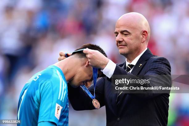 Thibaut Courtois of Belgium is presented with his third place medal by FIFA President Gianni Infantino after the 2018 FIFA World Cup Russia 3rd Place...