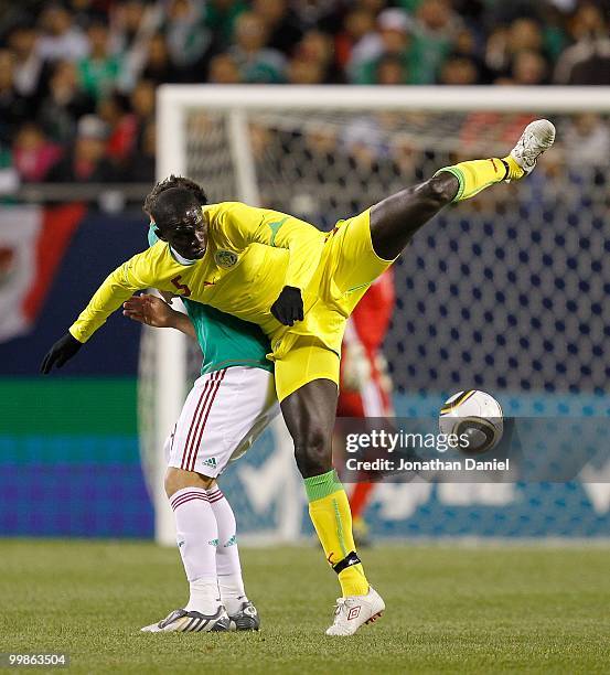 Moustapha Cisse of Senegal leaps for the ball and lands on the back of Hector Moreno of Mexico during an international friendly at Soldier Field on...