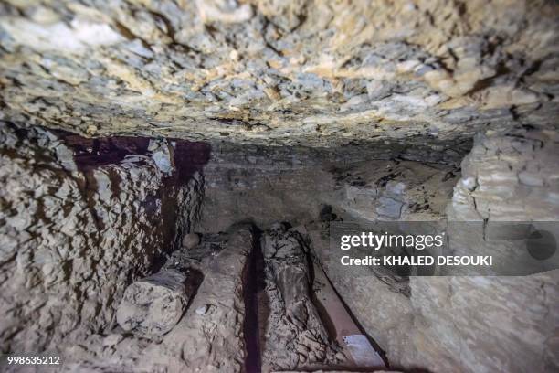 Picture taken on July 14, 2018 shows remains of mummies inside a burial chamber, in the Saqqara necropolis, south of the Egyptian capital Cairo on...