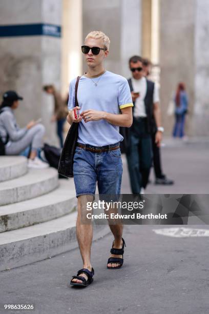 Guest wears a blue t-shirt, blue denim shorts, sandals, outside Lanvin, during Paris Fashion Week - Menswear Spring-Summer 2019, on June 24, 2018 in...