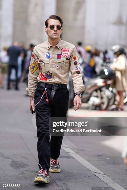 Guest wears a shirt with colored patches, black pants, sneakers shoes, outside Lanvin, during Paris Fashion Week - Menswear Spring-Summer 2019, on...