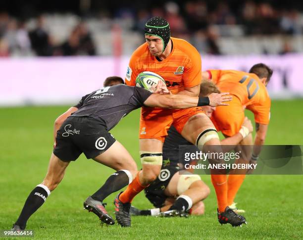 Jaguares' lock Matias Alemanno is tackled by Sharks' scrum half Louis Schreuder during the Super Rugby match between the Sharks and the Jaguares at...