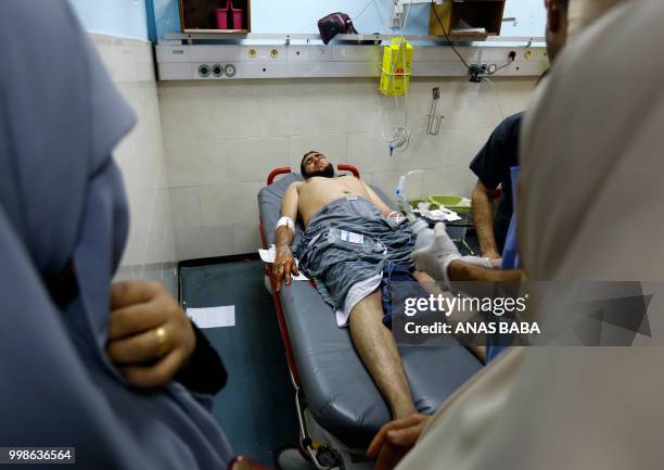 Graphic content / A Palestinian injured by Israeli air strikes receives medical attention as he lies in an emergency room at al-Shifa hospital in...