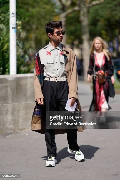 Guest wears a trench coat, a shirt, black pants, sneakers shoes, outside Lanvin, during Paris Fashion Week - Menswear Spring-Summer 2019, on June 24,...