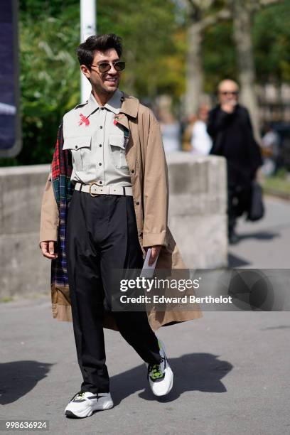 Guest wears a trench coat, a shirt, black pants, sneakers shoes, outside Lanvin, during Paris Fashion Week - Menswear Spring-Summer 2019, on June 24,...
