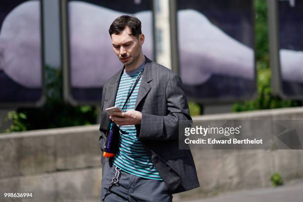 Guest wears a gray blazer jacket, a blue striped top, gray flared pants, outside Lanvin, during Paris Fashion Week - Menswear Spring-Summer 2019, on...