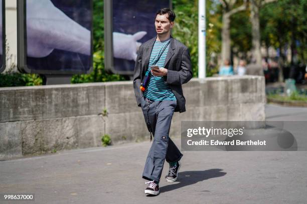 Guest wears a gray blazer jacket, a blue striped top, gray flared pants, outside Lanvin, during Paris Fashion Week - Menswear Spring-Summer 2019, on...