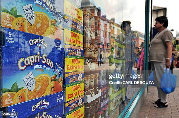 Woman looks in the window of a food store in Hounslow, west London on May 18, 2010. British annual inflation hit a 17-month high in April, official...