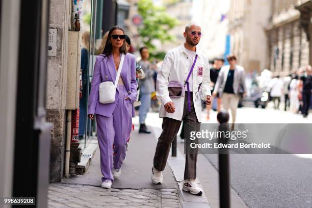 Alice Barbier wears a purple suit and a white bag ; Jean Sebastien Roques wears a white jacket, brown pants, sneakers, outside Thom Browne, during...