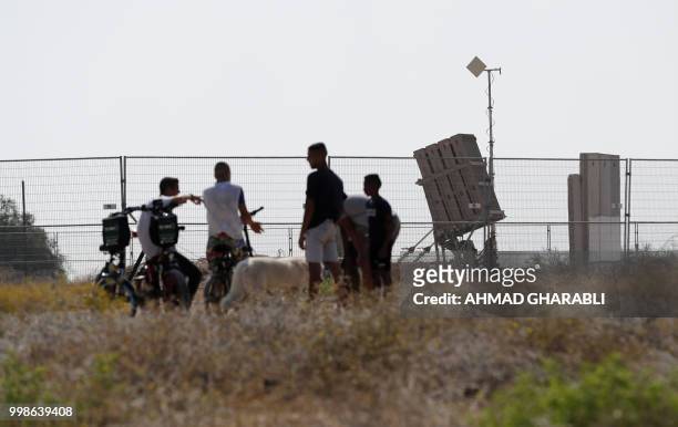 Israelis watch an Iron Dome defence system, designed to intercept and destroy incoming short-range rockets and artillery shells, near the city of...