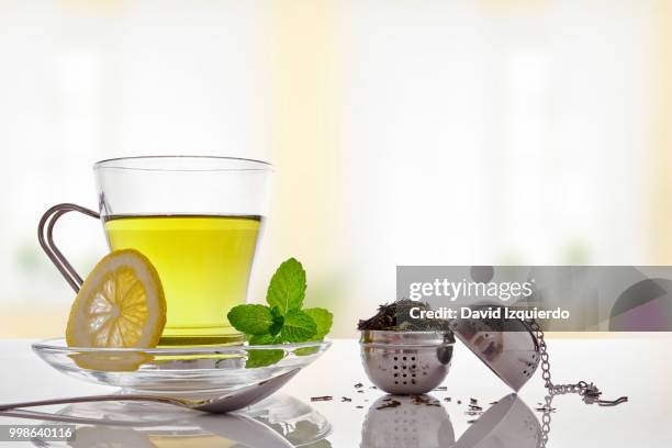 green tea with mint and lemon with strainer front view - lemon mint stock pictures, royalty-free photos & images