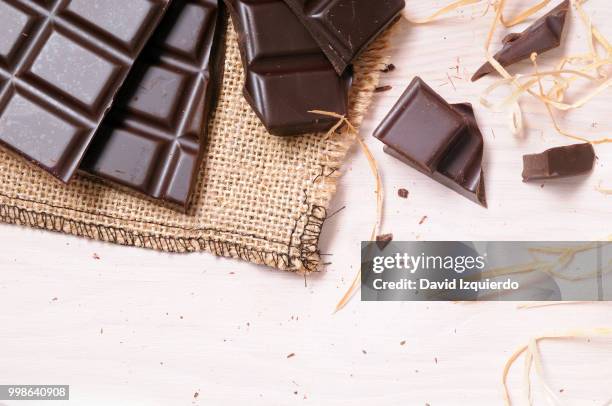 broken tablet artisan chocolate on a wooden table top view - chocolate top view imagens e fotografias de stock