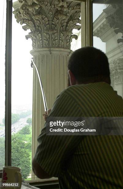 Female Cowbird is Rescued from the netting on top of a column outside the Senate Radio and T.V. Press Gallery by a worker from the Capitol useing a...