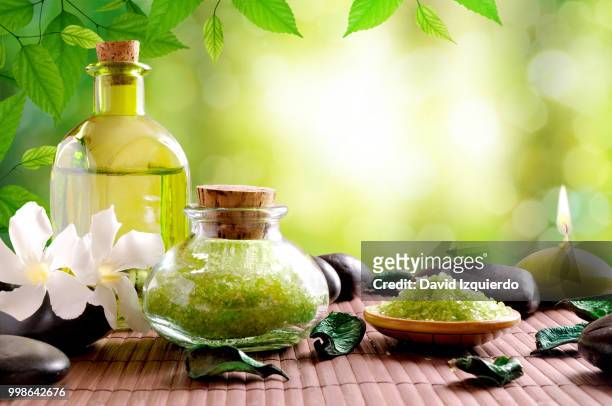 bath salts and body oil on wooden mat - bath mat stock pictures, royalty-free photos & images