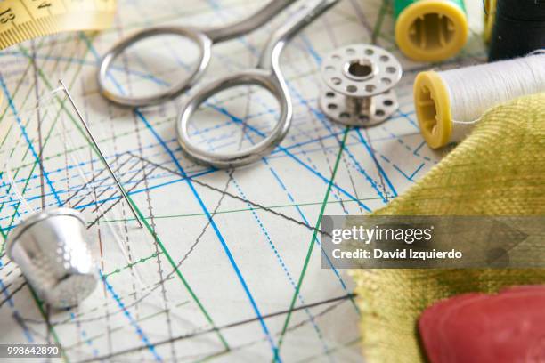 tailoring tools on clothing pattern elevated view - thimble stock pictures, royalty-free photos & images