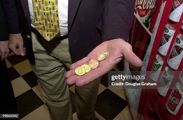 Jim Kolbe, R-AZ., shows off the new golden dollar at the Longworth Cafeteria and then uses them to buy snacks from the vending machines.