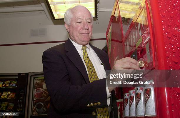 Jim Kolbe, R-AZ., uses the new golden dollar at the Longworth Cafeteria to buy snacks from the vending machines.