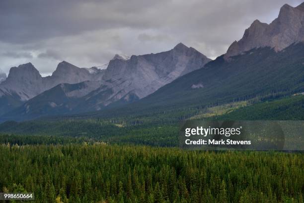 a look across the mountainside of the rundle peaks to the three sisters - mark rundele stock pictures, royalty-free photos & images