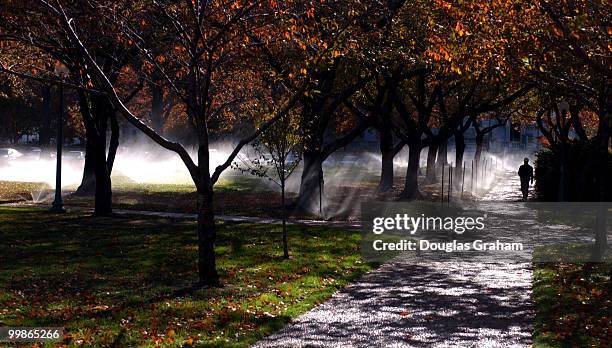 Worker for the Architect of the Capitol monitors the sprinkler system at the Senate Park near the Russell Senate Office Building.