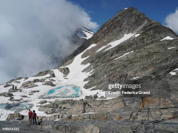 two hikers descending steep trail from monte moro - gneiss stock pictures, royalty-free photos & images